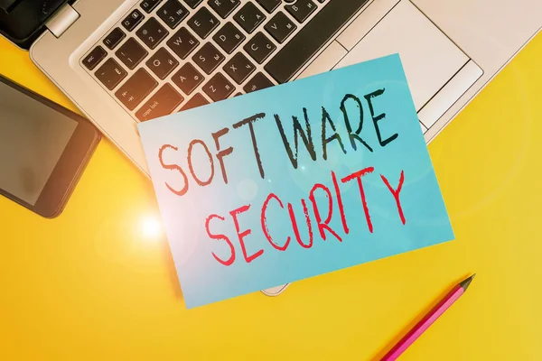 Writing note showing Software Security. Business photo showcasing implemented to protect software against malicious attack Metallic laptop small paper sheet pencil smartphone colored background.