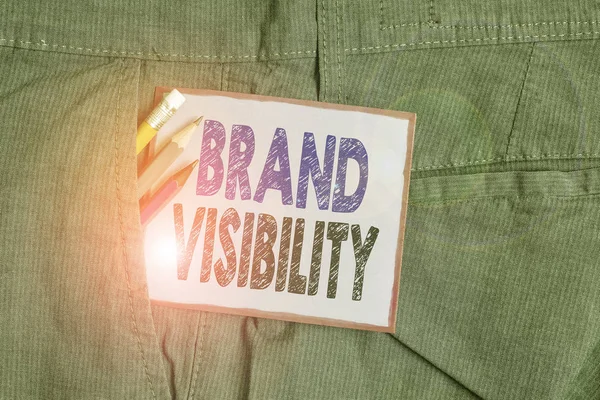 Tanda teks menunjukkan Brand Visibility. Frekuensi foto konseptual tempat menampilkan merek Anda dalam hasil pencarian Peralatan tulisan dan kertas catatan ungu di dalam saku celana kerja manusia . — Stok Foto