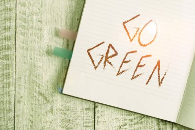 Go Green 'i gösteren bir not yazıyorum. Klasik ahşap zemin üzerine yerleştirilen geri dönüşüm dizaynını azaltmak için iş fotoğrafı sergisi çevre dostu kararlar veriyor.