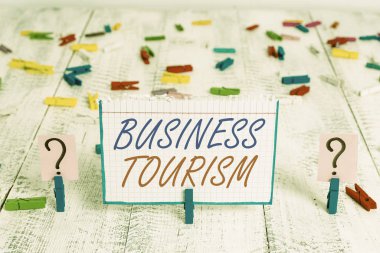 İş Turizmini gösteren kavramsal el yazısı. Ticari amaçla bırakılan resimlerin gösterildiği doğal bir yer. Ahşap masaya raptiye takılmış kağıt levhalar..