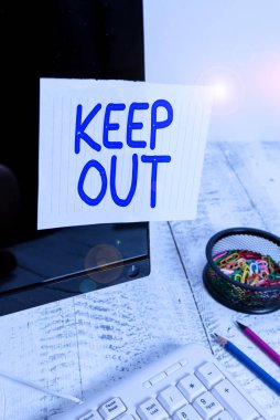 Uzak Dur 'u gösteren kavramsal el yazısı. İş fotoğrafı metni birinin ya da bir şeyin bir yere girmesini engellemek için Tehlike işareti Not kağıdı klavye durağanlığının yanındaki siyah ekrana bantlanmış.