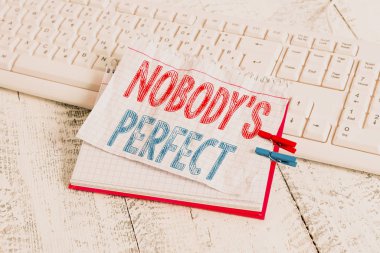 Text sign showing Nobody S Is Perfect. Conceptual photo used to say that everyone makes mistakes or fault notebook paper reminder clothespin pinned sheet white keyboard light wooden.