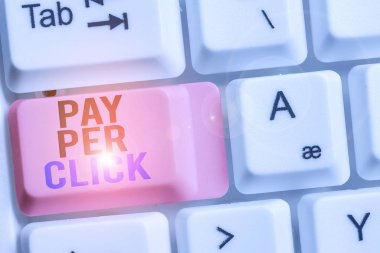 El yazısı, tıklama başına öde. Konsept: İnternet Reklam Model Arama Motoru Pazarlama Stratejisi Beyaz pc klavye üzerinde boş not kağıdı olan beyaz arkaplan anahtar alanı.