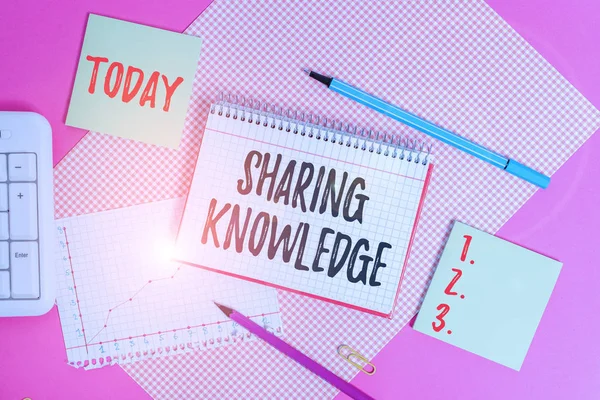 Text sign showing Sharing Knowledge. Conceptual photo knowledge is exchanged among showing or organizations Writing equipments and computer stuffs placed above colored plain table.