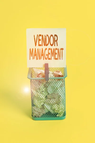 Conceptual hand writing showing Vendor Management. Business photo text activities included in researching and sourcing vendors Trash bin crumpled paper clothespin office supplies yellow.