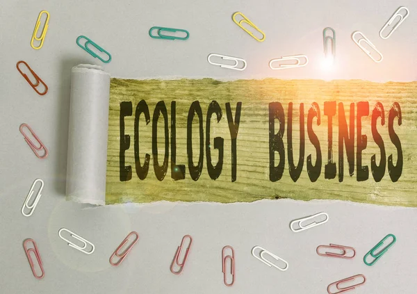 エコロジービジネスを示す概念的な手書き。地球環境・環境保護事業を紹介するビジネス写真紙クリップと木のクラッシックテーブルを背景にした破れた段ボール. — ストック写真