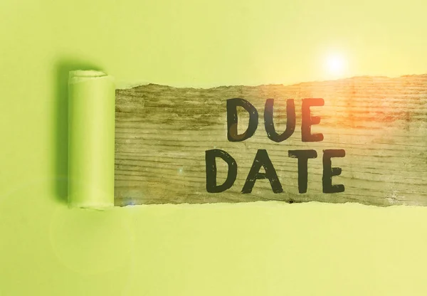 Word writing text Due Date. Business concept for The date when payment should be received by the demonstrating or company Cardboard which is torn in the middle placed above a wooden classic table.