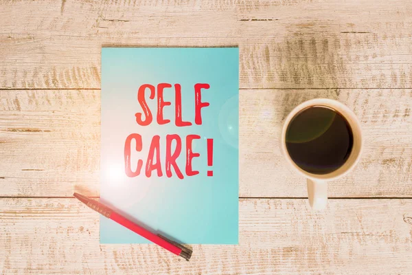 Writing note showing Self Care. Business photo showcasing practice of taking action preserve or improve ones own health Stationary placed next to a cup of black coffee above the wooden table. — Stock Photo, Image