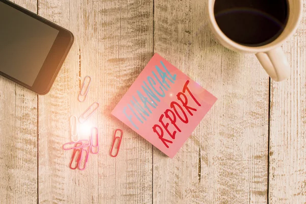 Text sign showing Financial Report. Conceptual photo formal records of the financial activities of a business Stationary placed next to a cup of black coffee above the wooden table.