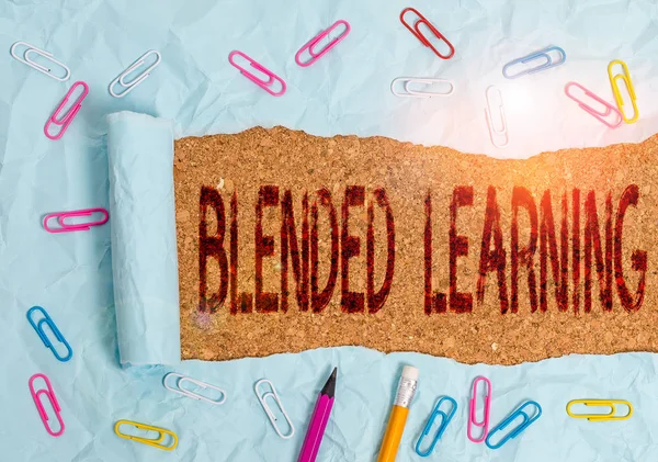 Conceptual hand writing showing Blended Learning. Business photo text combines traditional classroom lessons with online teaching Stationary and torn cardboard on a wooden classic table backdrop.