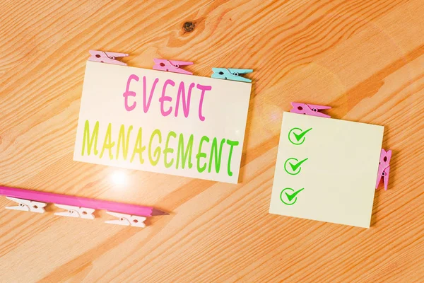 Word writing text Event Management. Business concept for job of planning and analysisaging large events or conferences Colored clothespin papers empty reminder wooden floor background office.