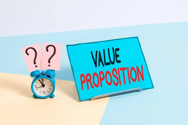 Writing note showing Value Proposition. Business photo showcasing make a company or product attractive to customers Alarm clock beside a Paper sheet placed on pastel backdrop. — ストック写真