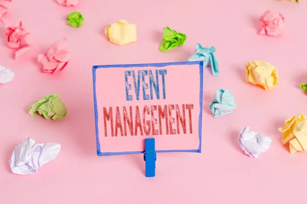 Word writing text Event Management. Business concept for job of planning and analysisaging large events or conferences Colored crumpled papers empty reminder pink floor background clothespin.