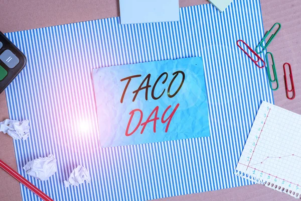 Handwriting text Taco Day. Concept meaning celebratory day that promotes to consumption of tacos in the US Striped paperboard notebook cardboard office study supplies chart paper.