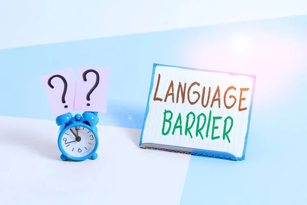 Conceptual hand writing showing Language Barrier. Business photo text difficulties in communication Speaking different language Alarm clock beside a Paper sheet placed on pastel backdrop.