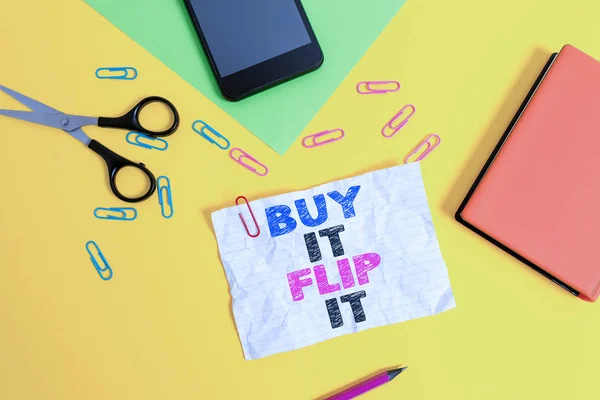 Text sign showing Buy It Flip It. Conceptual photo Buy something fix them up then sell them for more profit Paper sheets pencil clips smartphone scissors notebook colored background.