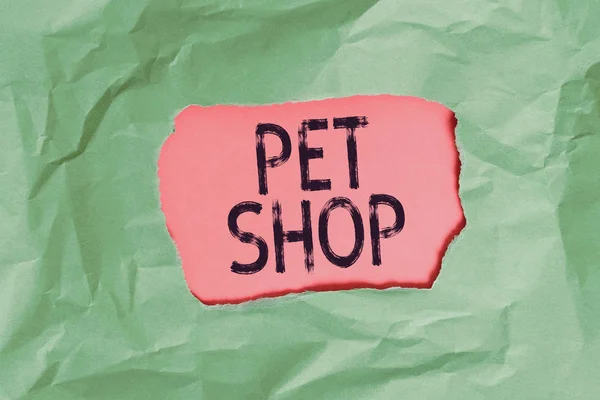 手写文字宠物店。概念意思是向公众出售各种动物的零售业务。绿色皱皱撕破的彩色纸片中心撕破彩色背景. — 图库照片