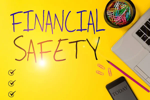 Text sign showing Financial Safety. Conceptual photo enough money saved to cover emergencies and financial goals Slim trendy laptop pencil smartphone clips container colored background.