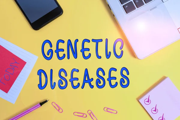 Text sign showing Genetic Diseases. Conceptual photo disease caused by an abnormality in an individual s is genome Laptop smartphone notepad marker paper sheet note clips colored background.