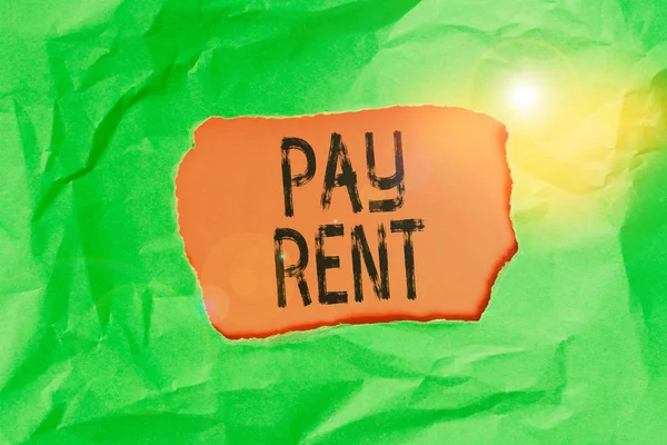 Handwriting text Pay Rent. Concept meaning To pay money in exchange for the use of someone else s is property Green crumpled ripped colored paper sheet centre torn colorful background.