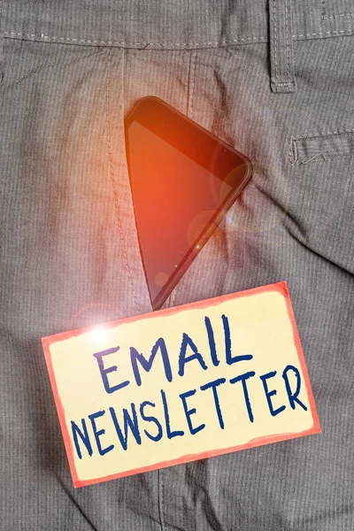 Handwriting text writing Email Newsletter. Concept meaning email sent out to inform the audience of the latest news Smartphone device inside formal work trousers front pocket near note paper.