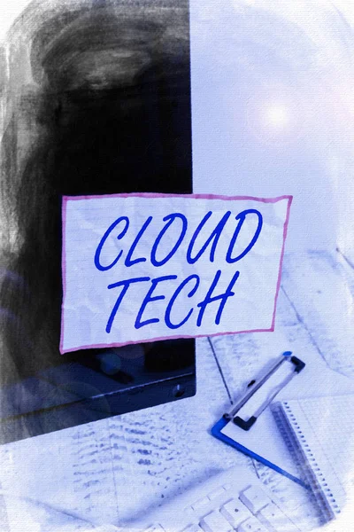 Text sign showing Cloud Tech. Conceptual photo storing and accessing data and programs over the Internet Note paper taped to black computer screen near keyboard and stationary.