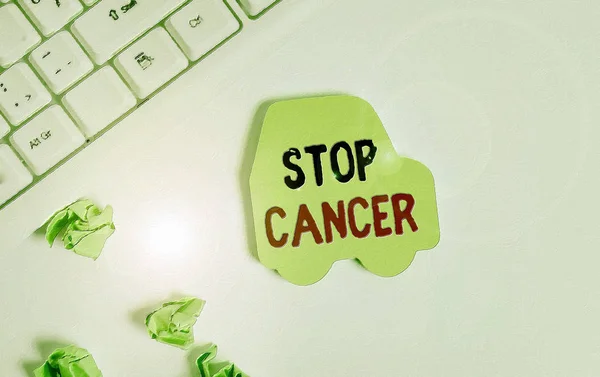 Handwriting text writing Stop Cancer. Concept meaning prevent the uncontrolled growth of abnormal cells in the body Green note paper in the shape of the car. Copy space on the green note paper.