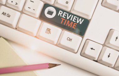 Gözden Geçirme Süresini gösteren not yazma. İş fotoğrafı yeniden düşünmek veya bir şey hakkında konuşmak için vitrin beyaz arka plan üzerinde not kağıdı ile Beyaz pc klavye gözden geçirmek için zamanlama ayarlayın.