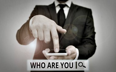 Text sign showing Who Are Youquestion. Conceptual photo someone asking your demonstratingal background or history Male human wear formal work suit hold smart hi tech smartphone use one hand.