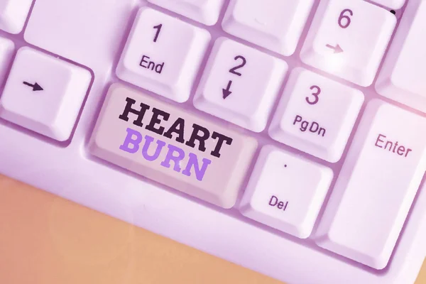 Scrittura concettuale a mano che mostra Heart Burn. Business photo testo una sensazione di bruciore o dolore alla gola da reflusso acido Tastiera bianca pc con carta nota sopra lo sfondo bianco . — Foto Stock