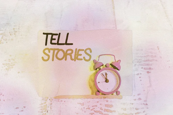 Word writing text Tell Stories. Business concept for formal to tell someone about something that has happened Mini blue alarm clock stand tilted above buffer wire in front of notepaper.