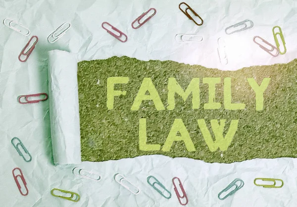 Text sign showing Family Law. Conceptual photo the branch of law that deals with matters relating to the family Paper clip and torn cardboard placed above a wooden classic table backdrop. — Stock Photo, Image