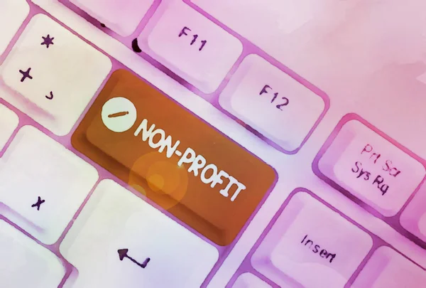 Text sign showing Non Profit. Conceptual photo type of organization that does not earn profits for its owners White pc keyboard with empty note paper above white background key copy space.