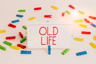 Old Life 'ı gösteren bir not yazıyorum. Önemli bir değişiklik olmadan önceki halimi gösteren bir iş fotoğrafı. Renkli çamaşır iğnesi kağıtları. Boş hatırlatıcı beyaz zemin arka plan ofisi..
