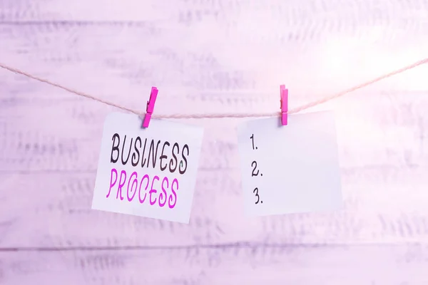 Text sign showing Business Process. Conceptual photo implemented to accomplish a target organizational goal Clothesline clothespin rectangle shaped paper reminder white wood desk. — Stockfoto