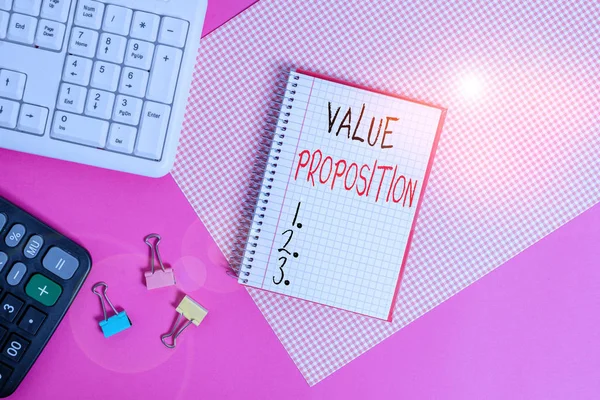 Handwriting text Value Proposition. Concept meaning make a company or product attractive to customers Writing equipments and computer stuffs placed above colored plain table. — Stock Photo, Image