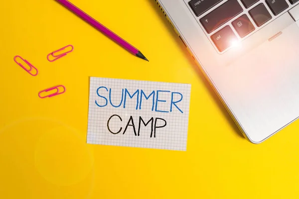 Ordskrivning text Summer Camp. Affärsidé för övervakade program för barn som genomförs under sommaren Trendig metallisk bärbar dator klipp penna kvadrat papper ark färgad bakgrund. — Stockfoto