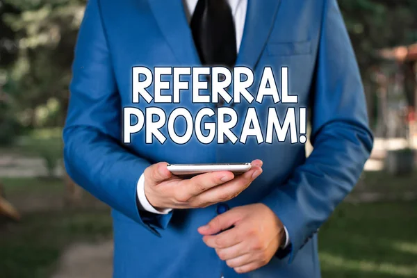 Konceptuální rukopis zobrazující Referral Program. Obchodní foto text interní náborové metody používané organizacemi Podnikatel v modrém apartmá stojí s mobilním telefonem v ruce. — Stock fotografie