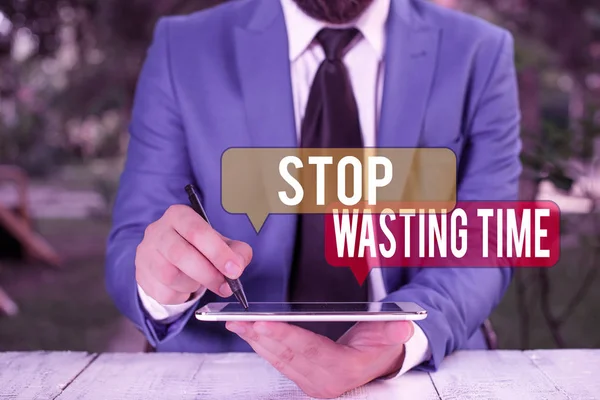 ［Stop Wasting Time］を示すテキスト記号。空のコピースペースでペンを指しているビジネスマンは賢明にそれを計画し、使用します。. — ストック写真