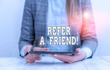 Conceptual hand writing showing Refer A Friend. Business photo text direct someone to another or send him something like gift Business woman sitting with mobile phone on the table.