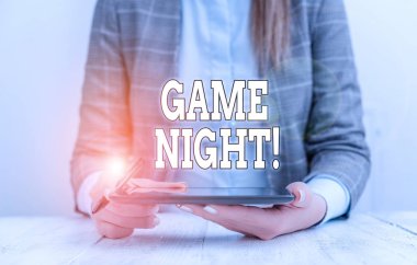 Oyun Gecesi 'ni gösteren kavramsal el yazısı. İş fotoğrafı metni genellikle arkadaşlarıyla poker gibi yetişkin oyun günlerinde masada cep telefonuyla oturan iş kadını olarak çağrılır..