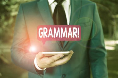 Gramer yazısını gösteren bir işaret. Kavramsal fotoğraf tüm sistem yapısı söz dizimi ve morfoloji İşadamı mavi süitte elinde cep telefonuyla duruyor.