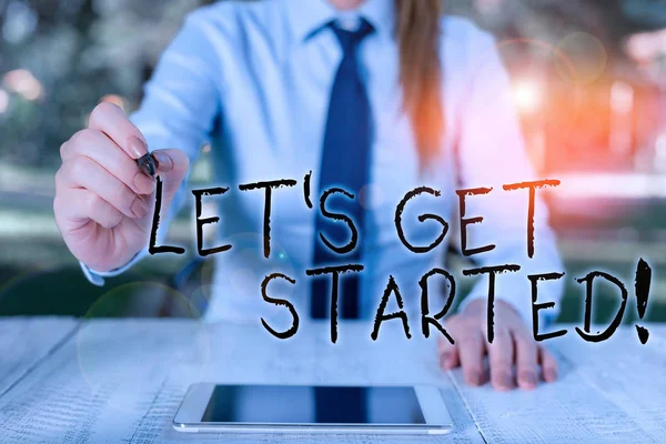 A Let S Get Start felirat. Fogalmi fotó ösztönzi valakit, hogy elkezd csinálni valamit Női üzletember ül az asztalnál, és tartja a mobiltelefon. — Stock Fotó