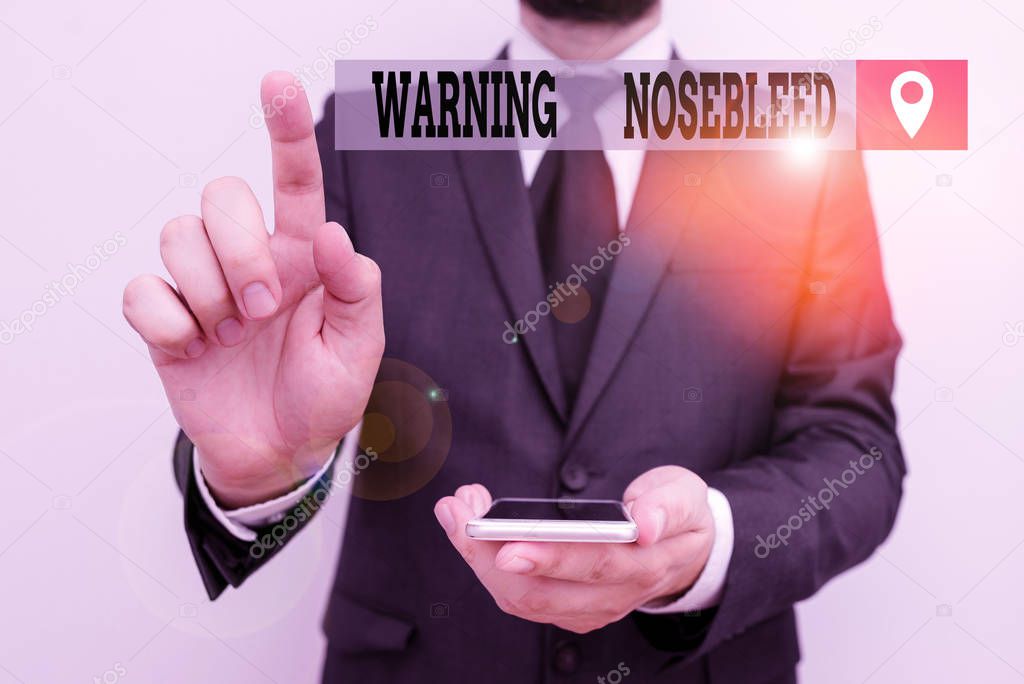 Writing note showing Warning Nosebleed. Business photo showcasing caution on bleeding from the blood vessels in the nose Male human wear formal work suit hold smartphone using hand.