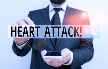 Text sign showing Heart Attack. Conceptual photo sudden occurrence of coronary thrombosis resulting in death Male human wear formal work suit hold smart hi tech smartphone use one hand.