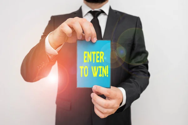 Word writing text Enter To Win. Business concept for exchanging something value for prize chance winning prize Male human wear formal work suit office look hold notepaper sheet use hand. — Stock Photo, Image