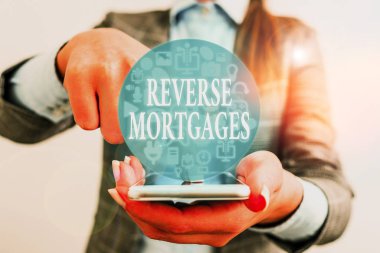 Handwriting text writing Reverse Mortgages. Concept meaning borrower to access the unencumbered value of the property. clipart