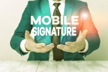 Mobil imzayı gösteren kavramsal el yazısı. Bir cep telefonunda oluşturulan dijital imzayı gösteren iş fotoğrafı. Önünde kopyalama alanı olan boş bir kağıt tutuyor..