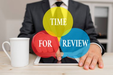 El yazısı metni İnceleme Zamanı. Bir sistemin ya da durumun resmi incelemesi anlamına gelir. Erkek insan resmi giysiler giyer. Sunum için yüksek teknoloji akıllı telefonu kullanın..