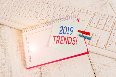 Metin 2019 Trends. Bir şeyin geliştirildiği ya da değiştirildiği genel yön anlamına geliyor. Kağıt hatırlatma, mandallı levha, beyaz klavye hafif ahşap..